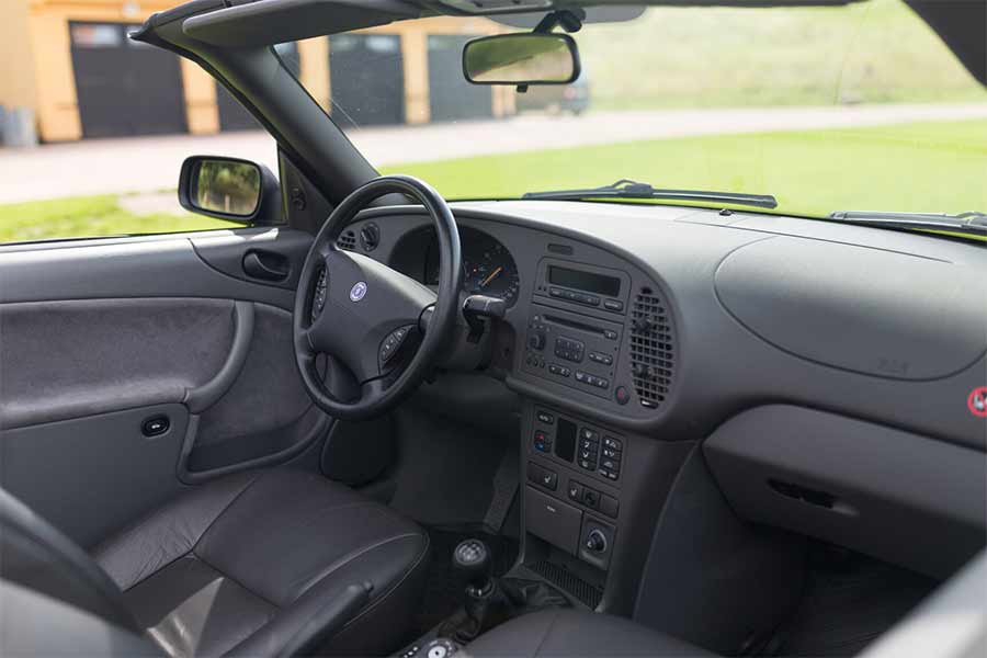 The interior of the 1998 Saab 9-3 SE 2.0T Convertible showcases its pristine condition, with well-preserved leather seats, an untouched dashboard, and all original details intact, reflecting the car's minimal use and meticulous care over the years.