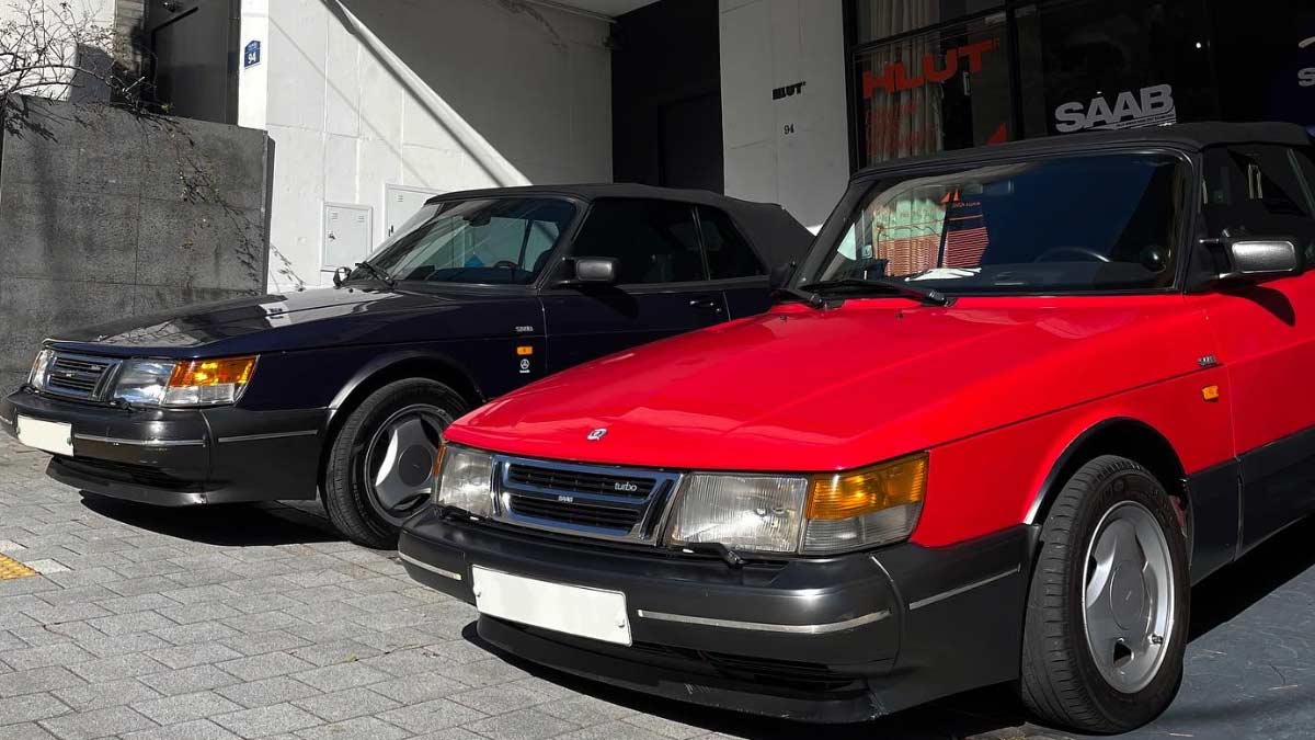 Vibrant gathering of Saab enthusiasts at the HLUT exhibition in Seoul, showcasing a rich tapestry of vintage Saabs and memorabilia.