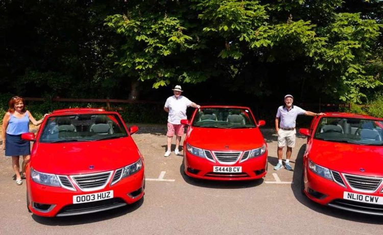 Uniting through their shared passion, Jane Hughes, Vincent O'Brien, and Charles Richards proudly pose with their rare red Saab convertibles, showcasing the timeless elegance of these remarkable vehicles against the backdrop of Formby's picturesque streets. Their chance meeting and love for these classic cars have created an unbreakable bond that continues to flourish in the heart of their tight-knit community.