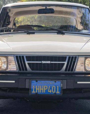 1983 Saab 900 in Ivory, showcasing its classic silhouette and timeless design on a serene road, embodying the joy of driving a vintage masterpiece.