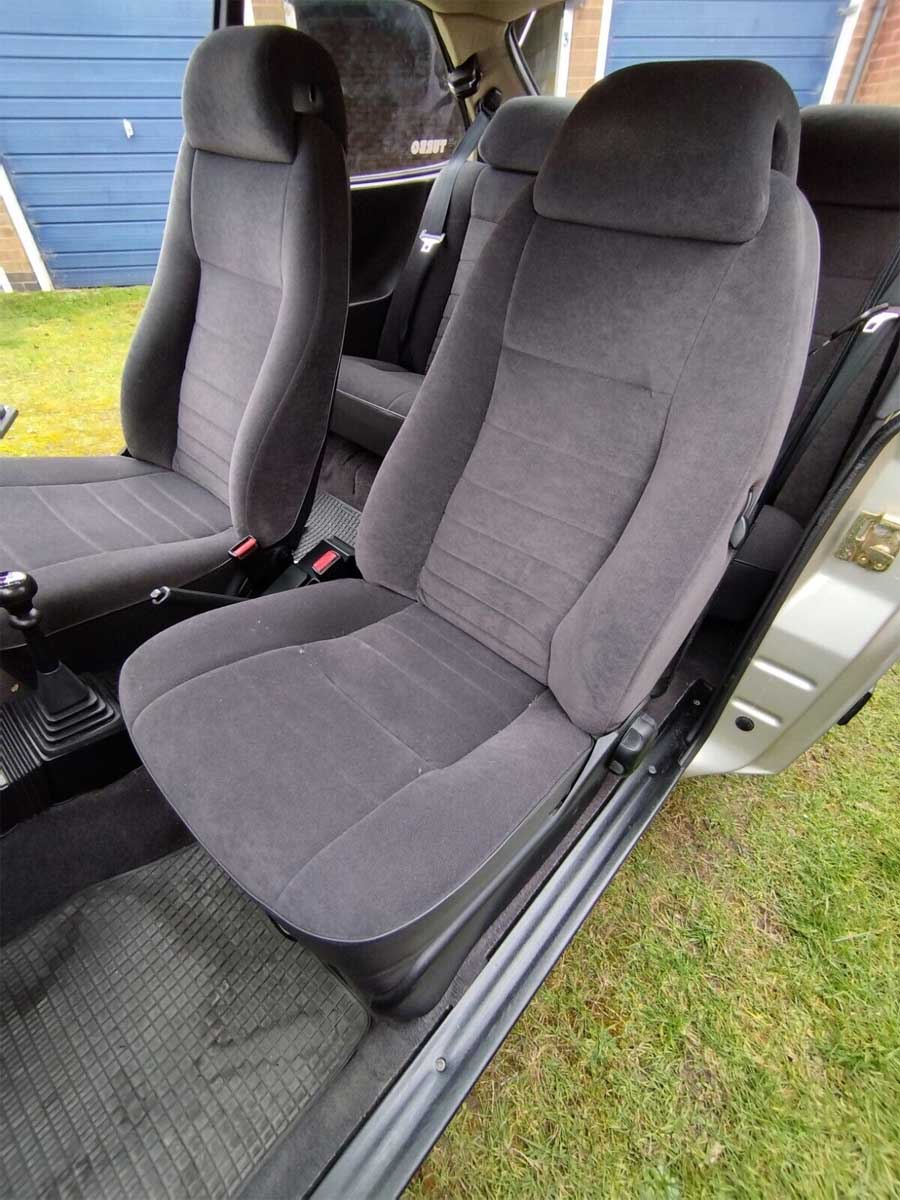 Interior view of the 1991 Saab 900 S Turbo, highlighting the pristine condition of its grey velour seats and well-maintained cabin.