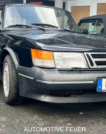 A well-preserved SAAB 900 Turbo 16 S, showcasing its iconic angular design and turbocharged performance, parked at an automotive event in Germany. The sleek black exterior and classic styling make this model a true standout in the world of vintage cars. Photo credit: Automotive Fever.