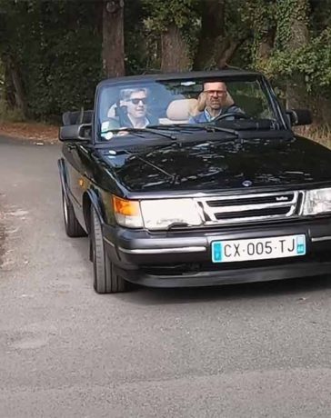 Ronan Rocher and Cedric Freour cruising in Ronan's classic Saab 900 Convertible during their interview for Petites Observations Automobiles (POA), showcasing the timeless elegance and performance of this iconic Swedish car.