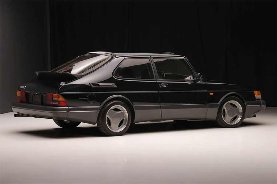 This studio shot of the 1988 Saab 900 Turbo SPG showcases its pristine black exterior and iconic three-spoke Aero wheels, highlighting the car's aerodynamic design and the upgraded R134a-based air conditioning system, making it a standout example of this rare model.