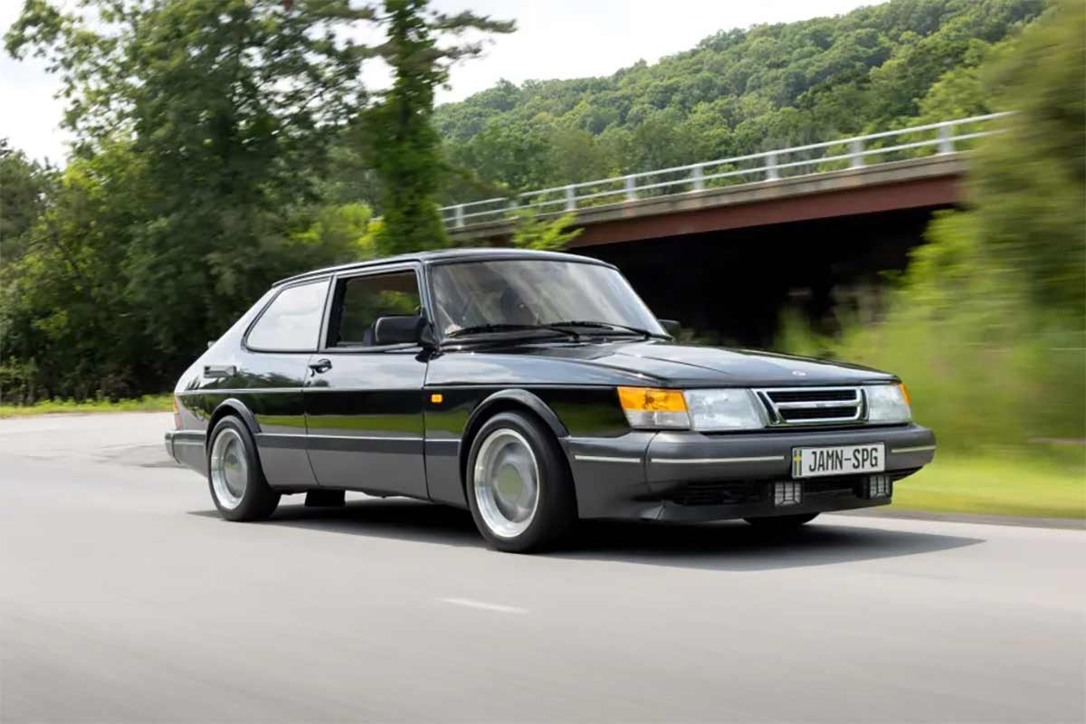 This stunning image of the 1988 Saab 900 Turbo SPG captures the essence of this rare and iconic vehicle, showcasing its sleek black exterior, aerodynamic design, and classic three-spoke Aero wheels, making it a perfect representation of the car's legendary performance and style.