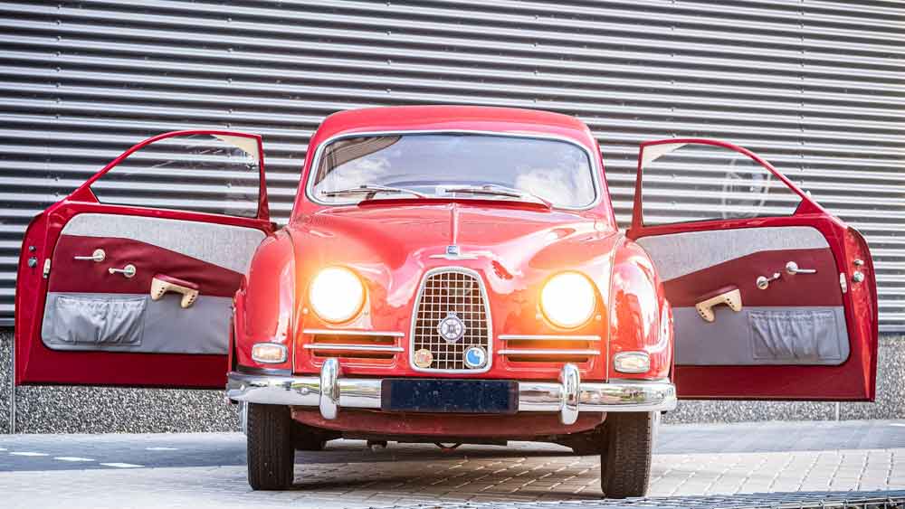 Opening doors to the past: The 1957 Saab 93B, with its distinctive red and white interior, invites admirers to step back in time.