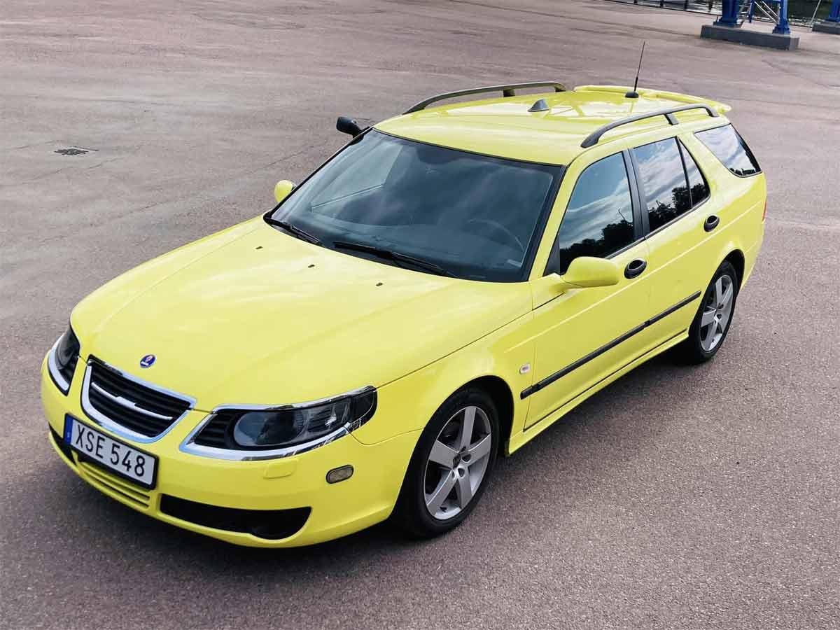 Peter's Saab at Auction: A Glimpse of Vibrant Ambulance Yellow – A unique moment as Peter's Saab 9-5 shines in its 'Ambulance Yellow' attire at an auction, devoid of medical equipment and chassis stickers, yet still resonating with its remarkable transformation