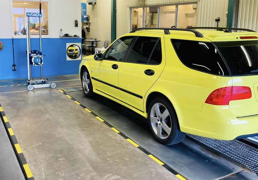 Peter's Saab Undergoes Inspection: A Look at the Transformation – A snapshot of Peter's Saab 9-5 during a technical inspection for re-registration, showcasing its meticulous restoration journey and unique 'Ambulance Yellow' exterior.