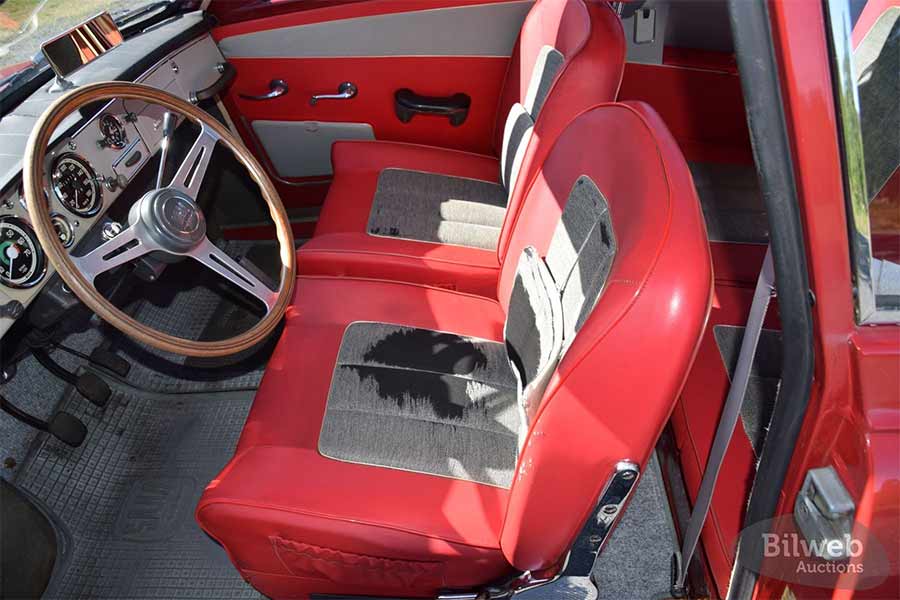 The original interior of this 1966 Saab 96 Monte Carlo 850 showcases its heritage, with well-preserved materials and the iconic wood-trimmed sport steering wheel.