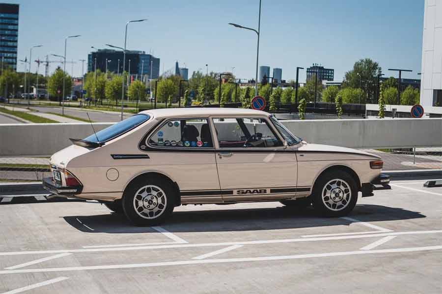 This shot beautifully showcases the classic 70s side stripe stickers, original Hella front spoiler, and SAAB boot lid spoiler. The refurbished "Footballs" wheels and new chrome windscreen trim emphasize the meticulous exterior restoration, making this vintage Saab a standout.