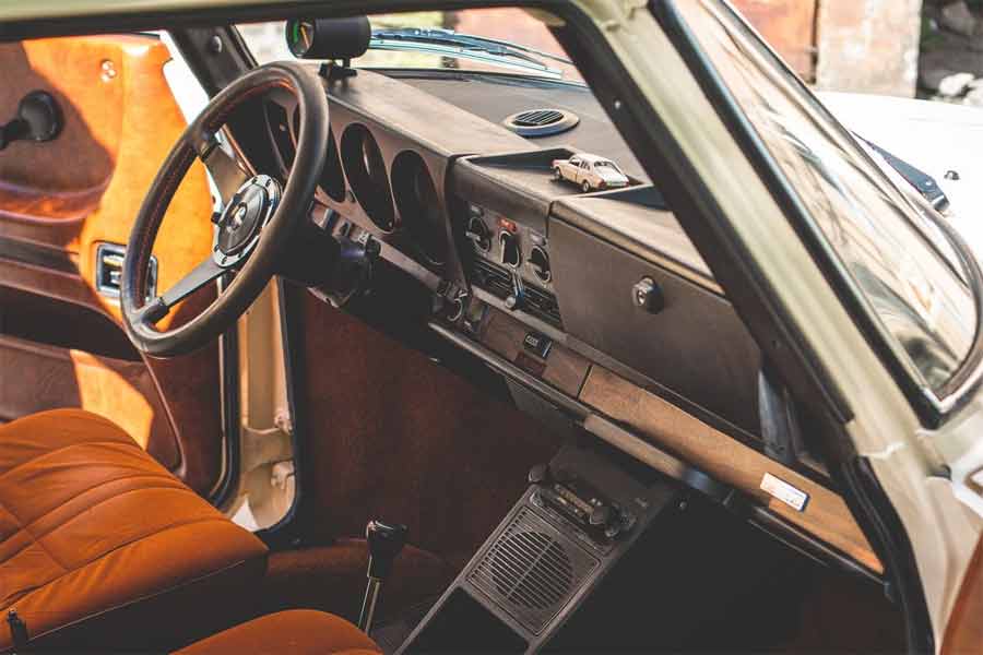 Interior of the 1975 SAAB 99 Combi Coupe Automatic – The well-preserved dashboard, classic steering wheel, and retro upholstery showcase the meticulous attention to detail in the restoration of this vintage Saab, reflecting its authentic 70s charm.