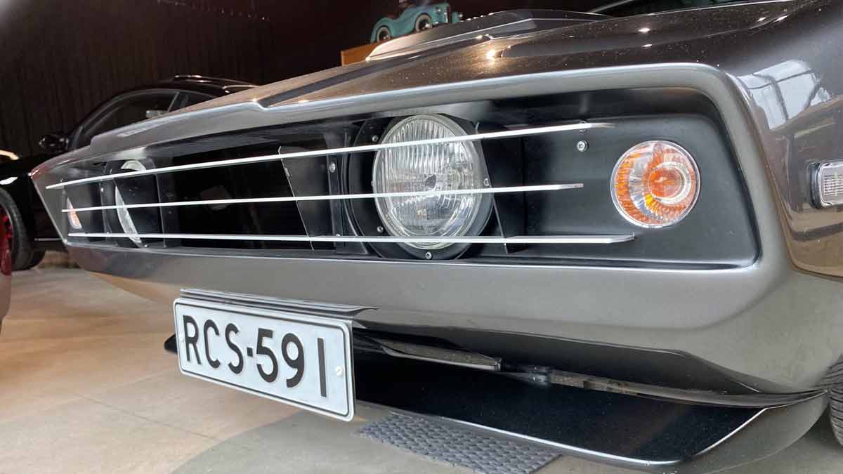 Close-up of the front grille and headlights of a 1973 Saab Sonett III, showcasing its distinctive design and well-maintained condition, featuring a Finnish registration plate.