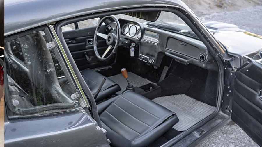 Interior of the 1973 Saab Sonett III featuring black leather-trimmed factory bucket seats with signature lumbar cushions, a wooden gear knob, and a period-correct dashboard layout, offering a blend of vintage charm and performance-focused upgrades.