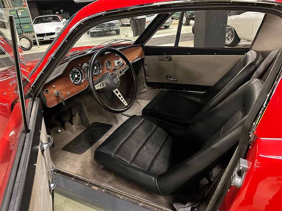 he meticulously restored interior of the 1966 Saab Sonett II prototype showcases timeless Scandinavian design, featuring a wood-accented dashboard and a driver-focused layout, exuding vintage charm.