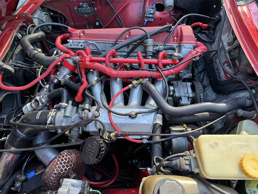 The heart of the modified 1990 Saab 900 Turbo SPG: a turbocharged 2.0-liter engine with Turbonetics T3/T4 turbo, aluminum intercooler, and striking red powder-coated components.