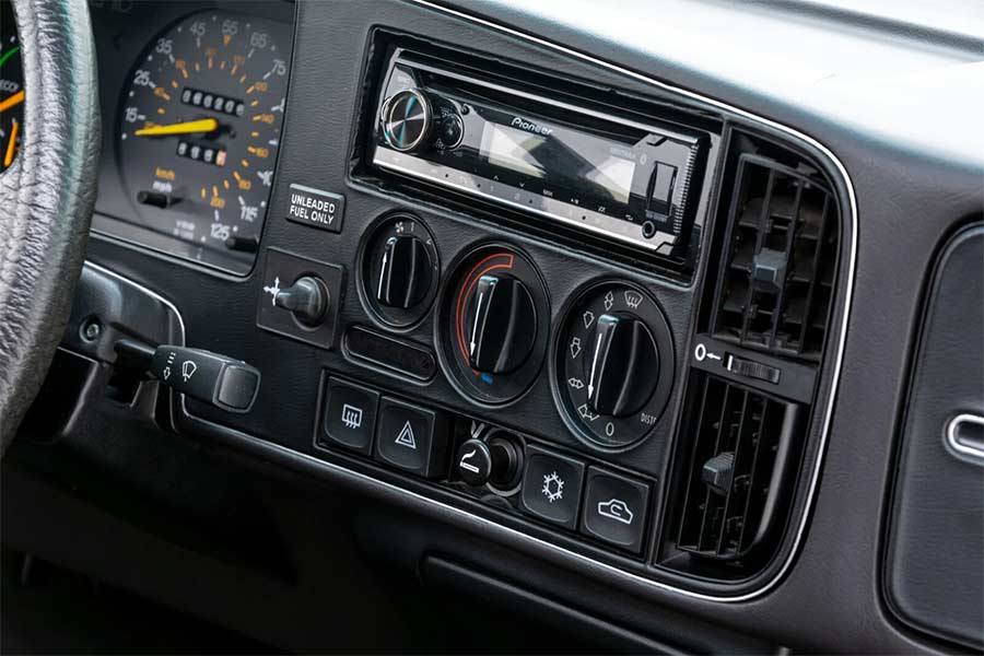 The dashboard of the 1986 Saab 900 SPG, featuring a spotless layout with updated audio and factory-original controls, exemplifying its immaculate preservation.