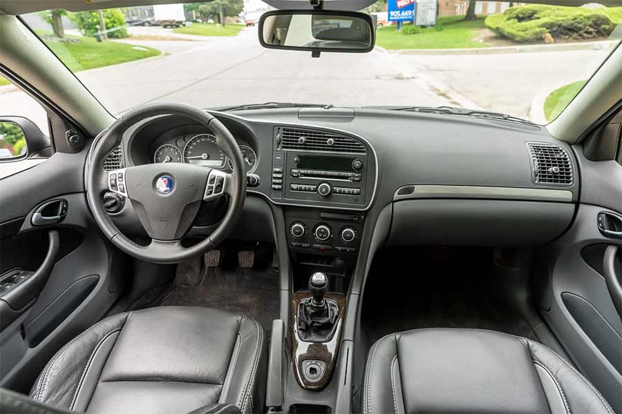 Step inside the 2007 Saab 9-3 SportCombi: an elegant cabin featuring upgraded leather seats, a six-speed manual shifter, and sophisticated dual-zone climate control, offering a blend of luxury and functionality.