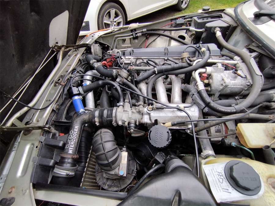 Under the hood of the 1991 Saab 900 S Turbo, featuring a meticulously maintained engine with advanced turbo and intercooler upgrades.