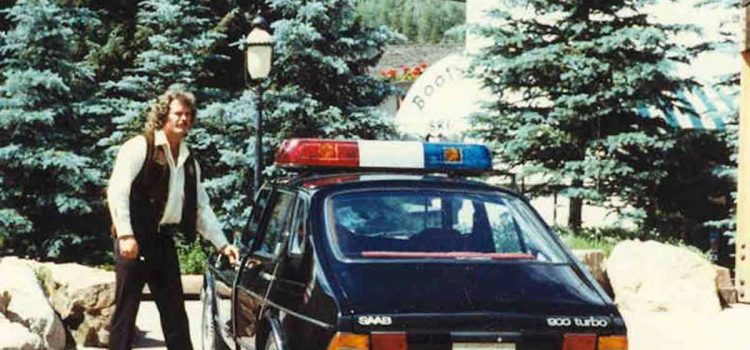 During the late 1970s or early 1980s, Vail Police Officer Pat McCullough examines one of the department's newly acquired Saab patrol cars, as the department marks its 50th anniversary this week.