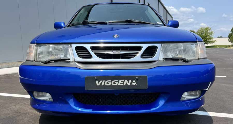 A front view of the 1999 Saab 9-3 Viggen in Lightning Blue Metallic, showcasing its distinctive grille and bumper design. The Viggen badge is prominently displayed, highlighting its special edition status.