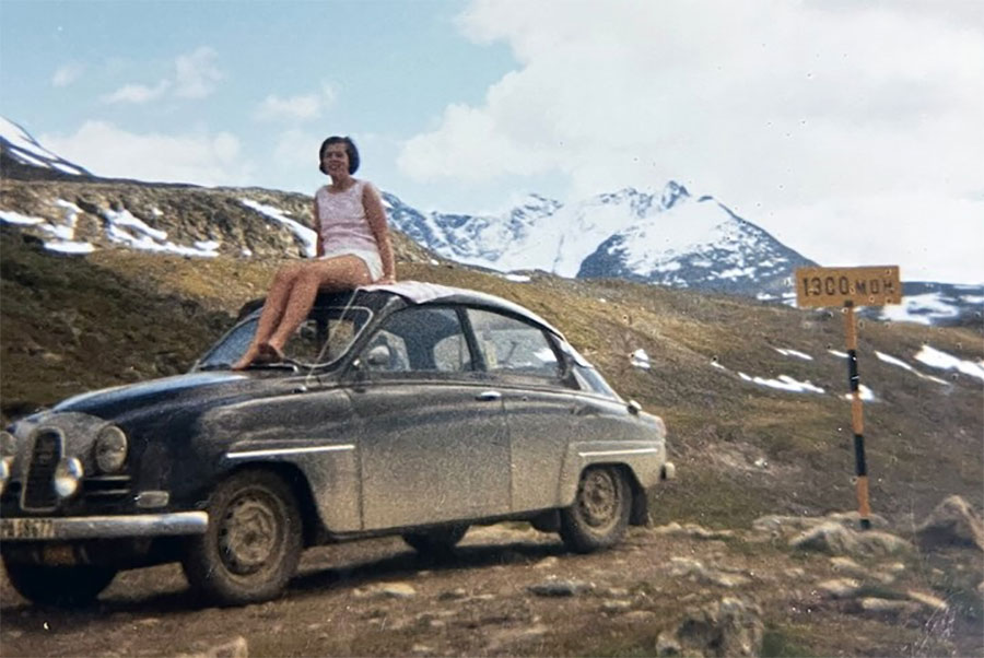 Ingalill perched atop the family’s midnight-blue Saab 96 in the Norwegian mountains, capturing the carefree spirit of exploration and adventure.